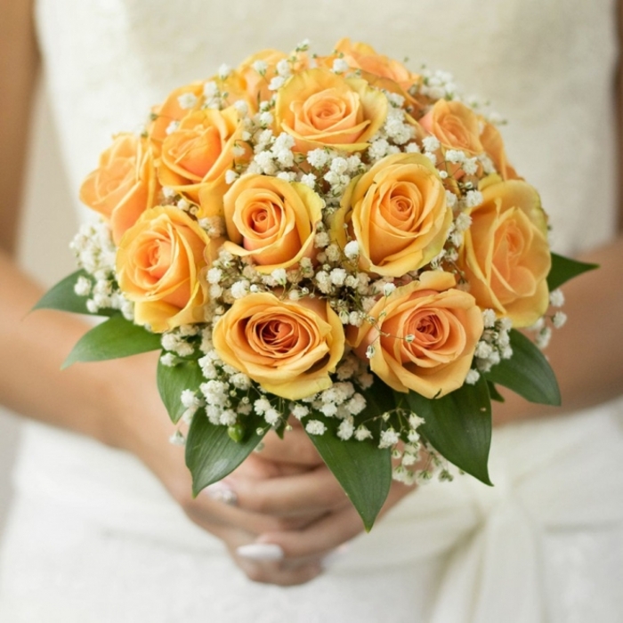 Looking at this bouquet, I see an ode to gentle romance-roses, densely gathered and awash in soft, glowing shades of yellow-orange, hint at the sunrise over Pentonville Road and the hope a new wedding day brings. Interspersed throughout are clouds of baby's breath, bringing an ethereal softness that feels like a quiet morning mist hovering along the gardens of Wilmington Square. The bouquet is anchored with glossy, deep green leaves that offer structure and stability, creating a harmonious juxtaposition against the tender roses. The tactile dance between the smooth, satiny rose petals and the feathery whiteness of gypsophila feels comforting and timeless, as if holding a piece of local Finsbury history. The bouquet is compact and perfectly balanced in the bride's hands-ready to accompany her down the aisle at St Mark's Church, offering a feeling of warmth and serenity. A soft, subtle fragrance lingers, reflecting refined, understated artistry and a genuine devotion to floristry. Every fresh flower tells a story, ensuring this bouquet becomes not just an arrangement, but a memory to keep alive long after the last petal has fallen.